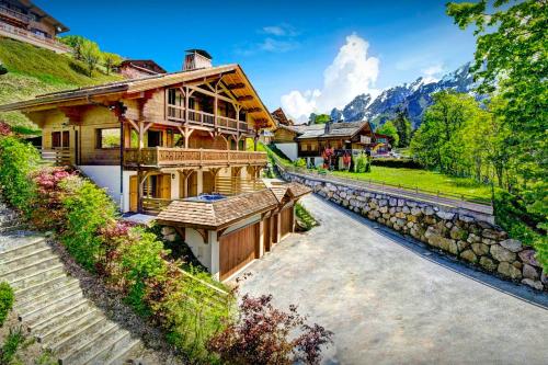 a house in the mountains with a stone wall at Chalet des Enfants La Clusaz - OVO Network in La Clusaz