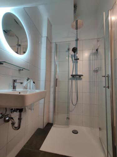 a bathroom with a sink and a shower with a mirror at Ort 245 in Ried im Innkreis
