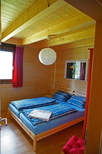 ein Schlafzimmer mit einem Bett in einem Holzzimmer in der Unterkunft Feriendorf Wutachschlucht in Mundelfingen