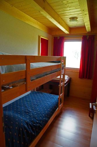 2 Etagenbetten in einem Zimmer mit Fenster in der Unterkunft Feriendorf Wutachschlucht in Mundelfingen