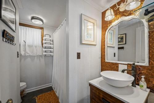 Rubys Roost في Mentone: حمام أبيض مع حوض ومرآة