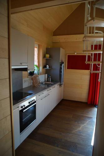 a kitchen with white cabinets and a stove top oven at Feriendorf Wutachschlucht in Mundelfingen