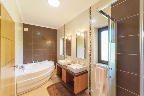 ein Bad mit einer Badewanne, einem Waschbecken und einer Dusche in der Unterkunft Villa Paraiso in São Bartolomeu de Messines