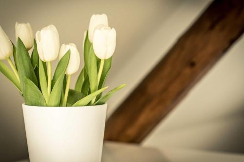 a white vase with white flowers in it at Chalet Sch l afbock in Priesteblich