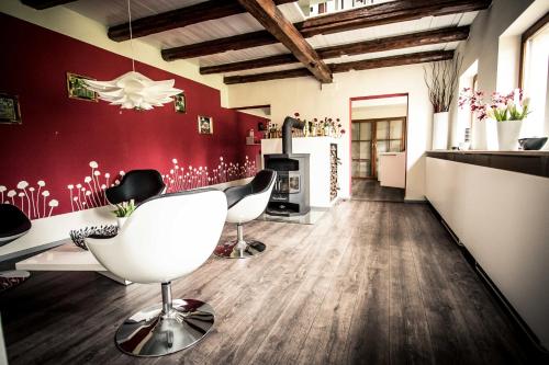 a living room with white chairs and a red wall at Chalet Sch l afbock in Priesteblich