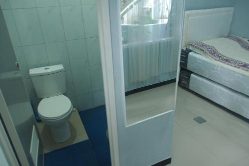 baño pequeño con aseo y ventana en Villa Ambu, en Bandung