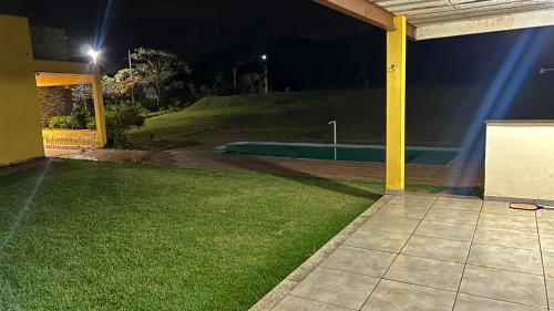 um quintal vazio à noite com uma piscina em Casa com piscina em itabirito em Lagoa dos Ingleses