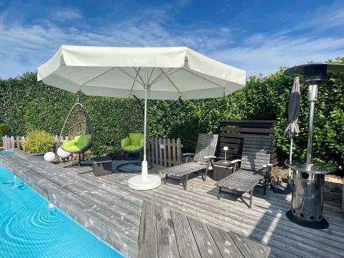 een witte paraplu op een terras naast een zwembad bij 4 Sterne Ferienwohnung Schlossblick Sauna Pool Whirlpool pri in Braunfels