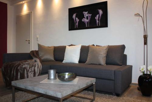 a living room with a couch and a coffee table at 4 Sterne Ferienwohnung Schlossblick Sauna Pool Whirlpool pri in Braunfels