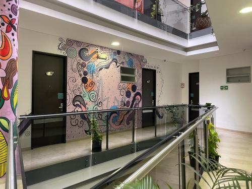 a lobby with a colorful mural on the wall at Hotel Bolivariana Plaza Medellin in Medellín