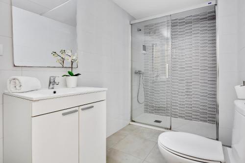 a white bathroom with a toilet and a shower at Carihuela Playa by IVI Real Estate in Torremolinos