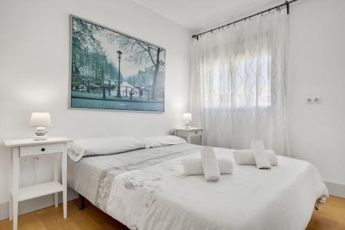 トレモリノスにあるCarihuela Playa by IVI Real Estateの白いベッドルーム(ベッド2台、窓付)