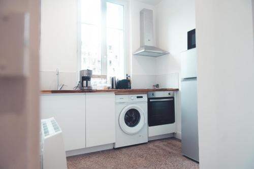 une cuisine blanche avec un lave-linge et un lave-linge dans l'établissement Le Cabernet, T2 centre ville, à Tours