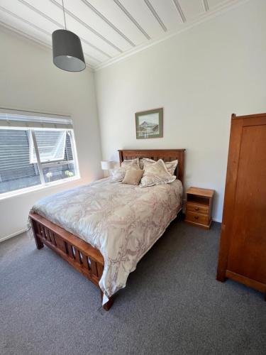 a bedroom with a large bed and a window at Eden Park House Auckland in Auckland