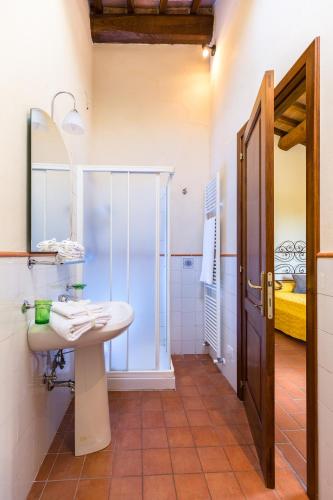 a bathroom with a sink and a glass shower at Casale Fontocchio in Cortona