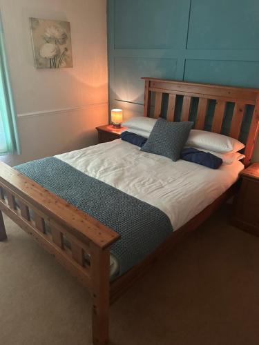 a bedroom with a wooden bed with two pillows at The Penruddocke Arms in Dinton