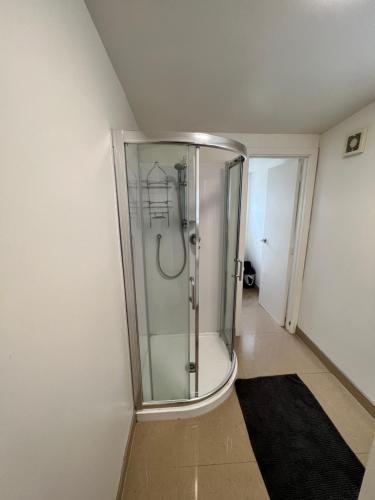 a glass shower in a room with a hallway at Eden Park House Auckland in Auckland