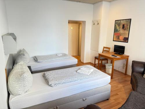 a room with two beds and a chair and a desk at Pension Sonnenschein in Halle an der Saale
