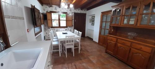 uma cozinha com uma mesa branca e cadeiras e uma mesa e armários em VIVIENDA VACACIONAL CASA PURA em Llanes