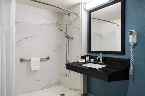 a bathroom with a sink and a shower with a mirror at La Quinta Inn by Wyndham Victoria in Victoria