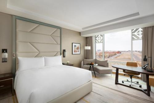 a bedroom with a large white bed and a desk at Crowne Plaza - Jeddah Al Salam by IHG in Jeddah