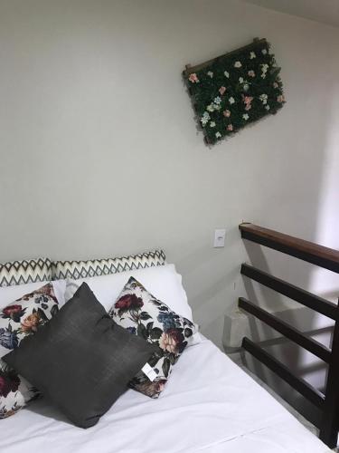 a bedroom with a bed with flowers on the wall at Residencial Estrela Guia 2 in Cabo Frio