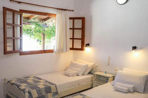 1 Schlafzimmer mit 2 Betten und einem Fenster in der Unterkunft Villa Amy in Achladies