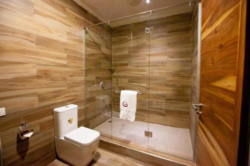 a bathroom with a toilet and a glass shower at Genesis Reventon Hotel in Port Harcourt