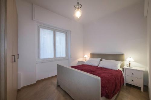 1 dormitorio con 1 cama con manta roja y ventana en Spiaggia e Gaslini, en Génova
