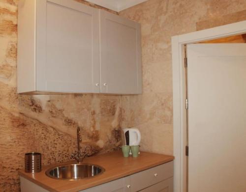 a kitchen with a sink and a white cabinet at Studio Barrakka Gardens in Valletta