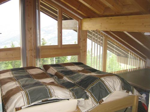 ein großes Bett in einem Zimmer mit Fenstern in der Unterkunft Chalet La Vigie in Modane