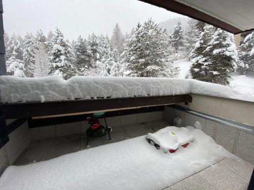 a snow covered balcony with a view of a snow covered forest at Bouffée d’oxygène in Uvernet