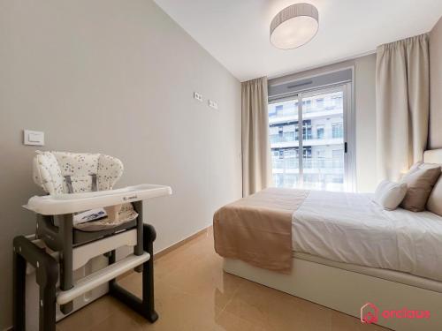 ein Schlafzimmer mit einem Bett, einem Stuhl und einem Fenster in der Unterkunft El Eden Costero in Cabanes