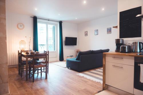 une cuisine et un salon avec une table et un canapé dans l'établissement Petit nid douillet, à Tours