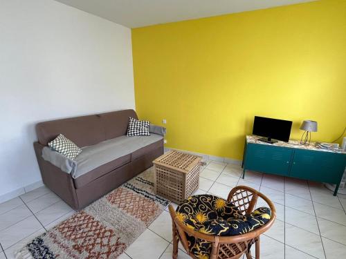 een woonkamer met een bank en een tv bij La Tranche Cozy Stay! in La Tranche-sur-Mer