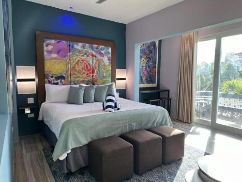 a bedroom with a bed with a large painting on the wall at Old Crow Hotel and Suites in Vieques