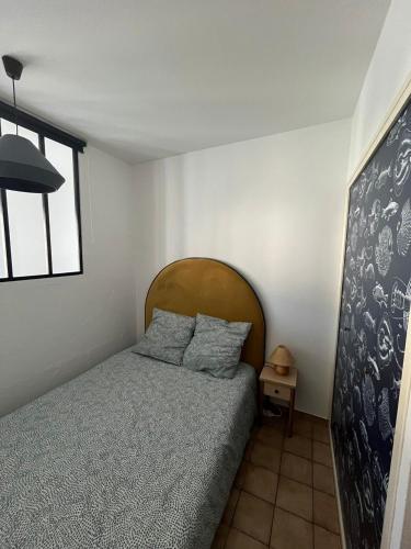 une chambre avec un lit avec une tête de lit en bois dans l'établissement La Tranche Cozy Stay!, à La Tranche-sur-Mer