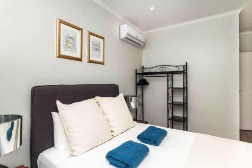 - une chambre avec un lit doté de 2 oreillers bleus dans l'établissement Lapa III Lisbon apartment, à Lisbonne