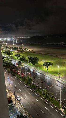een uitzicht op een straat 's nachts met auto's op de weg bij HAPPY STAY in São Vicente