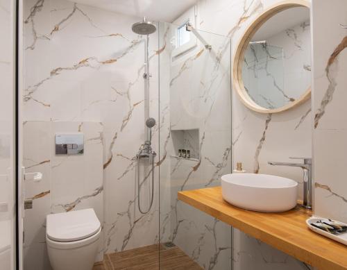 a bathroom with a toilet and a sink and a mirror at Anastasia Mare Studios in Pefkochori