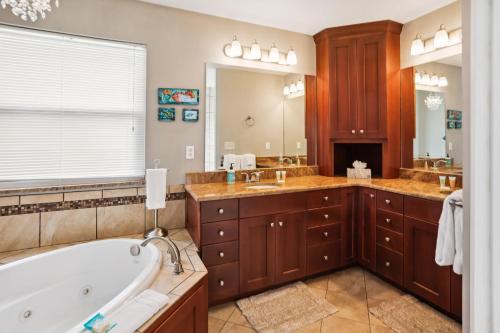 a bathroom with a tub and two sinks and a bath tub at Gulfport Getaway in St. Petersburg