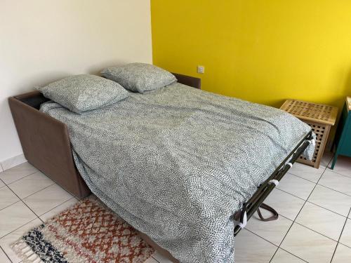 een slaapkamer met een bed met een grijs dekbed bij La Tranche Cozy Stay! in La Tranche-sur-Mer