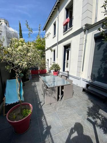 une terrasse avec une table et une plante en pot dans l'établissement Maison de ville La Défense, à Courbevoie