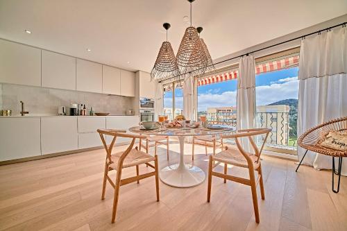 une cuisine avec une table et des chaises ainsi qu'une grande fenêtre dans l'établissement O Bambou-Superbe appartement-Saint-Tropez, à Saint-Tropez