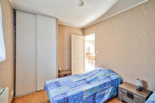 a bedroom with a bed and a sliding glass door at Pointe de la Torche à 5km- Maison pour 4- Surf in Plomeur