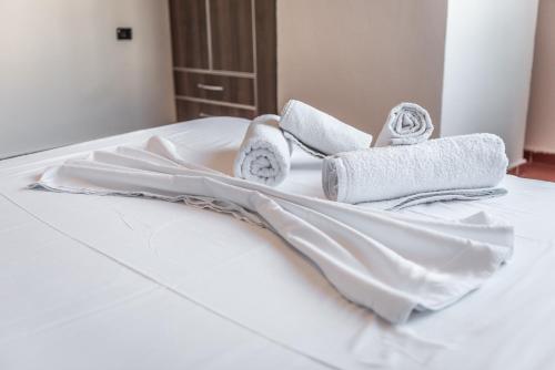 uma cama branca com toalhas por cima em Coastal Comfort by Premium Selection em Durrës