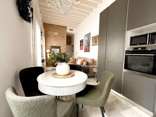 een woonkamer met een witte tafel en stoelen bij Ático Duplex Triana , Sevilla in Sevilla