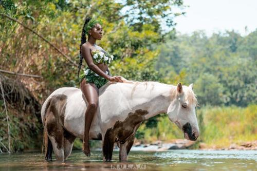 a woman sitting on a horse in the water at CosyLife Sainte-Rose - Villa familiale calme avec vue Sofaïa à 3km de la plage in Sainte-Rose