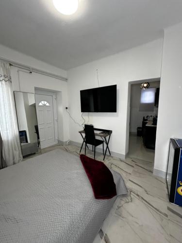 a white room with a bed and a flat screen tv at Airport17 B&B in Vecsés