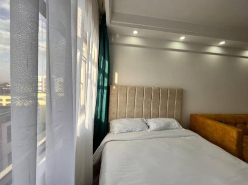 Cama en habitación con ventana en Amazing stylish Studio Apartment in Kilimani Nairobi, en Nairobi